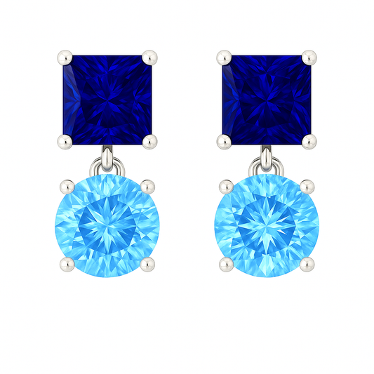 Elegant blue sapphire drop stud earrings with 5 mm princess and round, crafted in white gold-plated 925 silver with palladium-added alloy. Now at BSI Jewelry.