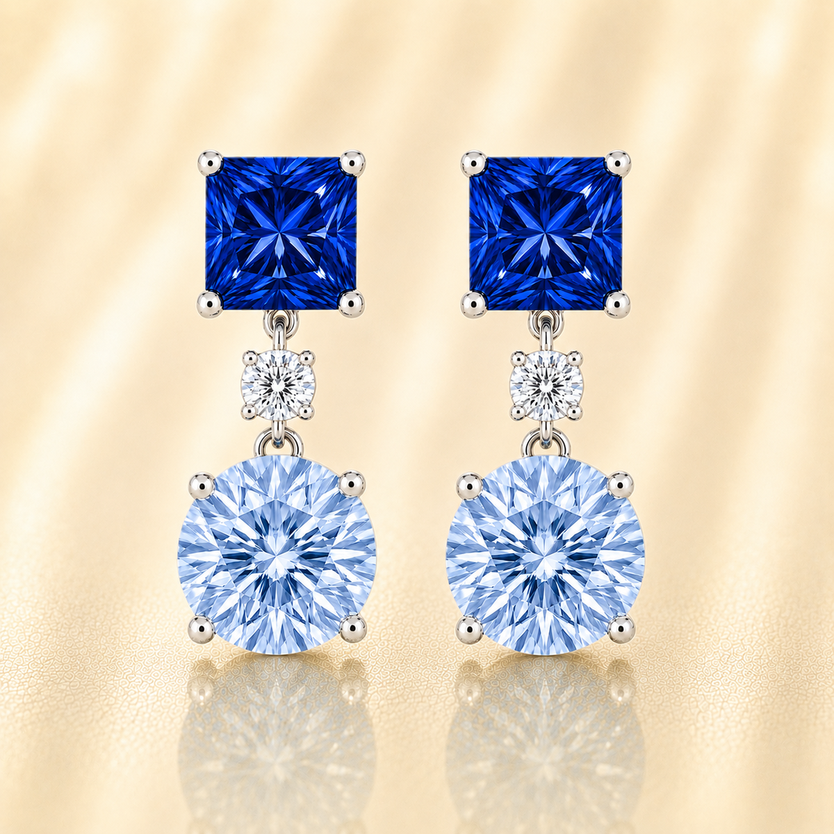 Elegant blue sapphire drop stud earrings with 5 mm princess and round, crafted in white gold-plated 925 silver with palladium-added alloy. Now at BSI Jewelry.