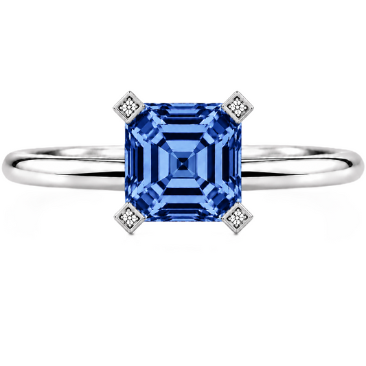 Royal blue sapphire engagement ring with a 6 mm asscher-cut center stone, crafted in white gold plated 925 silver. Available now at BSI Jewelry.
