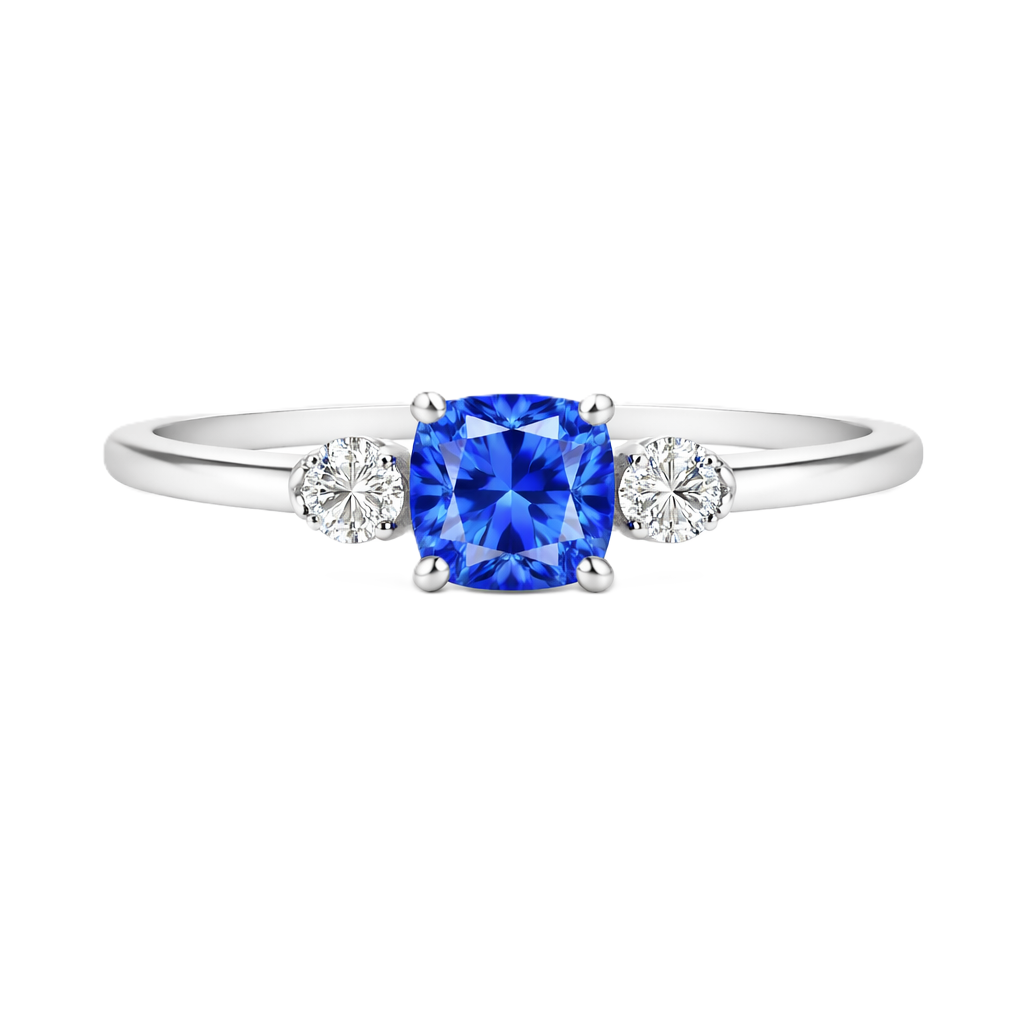 Blue sapphire engagement ring with 6 mm cushion center and 3 mm round side stones, crafted in white gold-plated 925 silver. Available now at BSI Jewelry.