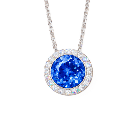 Blue sapphire pendant with 6 mm round stone in white gold-plated 925 silver, accented with moissanite and adjustable cable chain. Available now at BSI Jewelry.