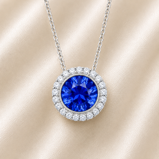 Blue sapphire pendant with 6 mm round stone in white gold-plated 925 silver, accented with moissanite and adjustable cable chain. Available now at BSI Jewelry.