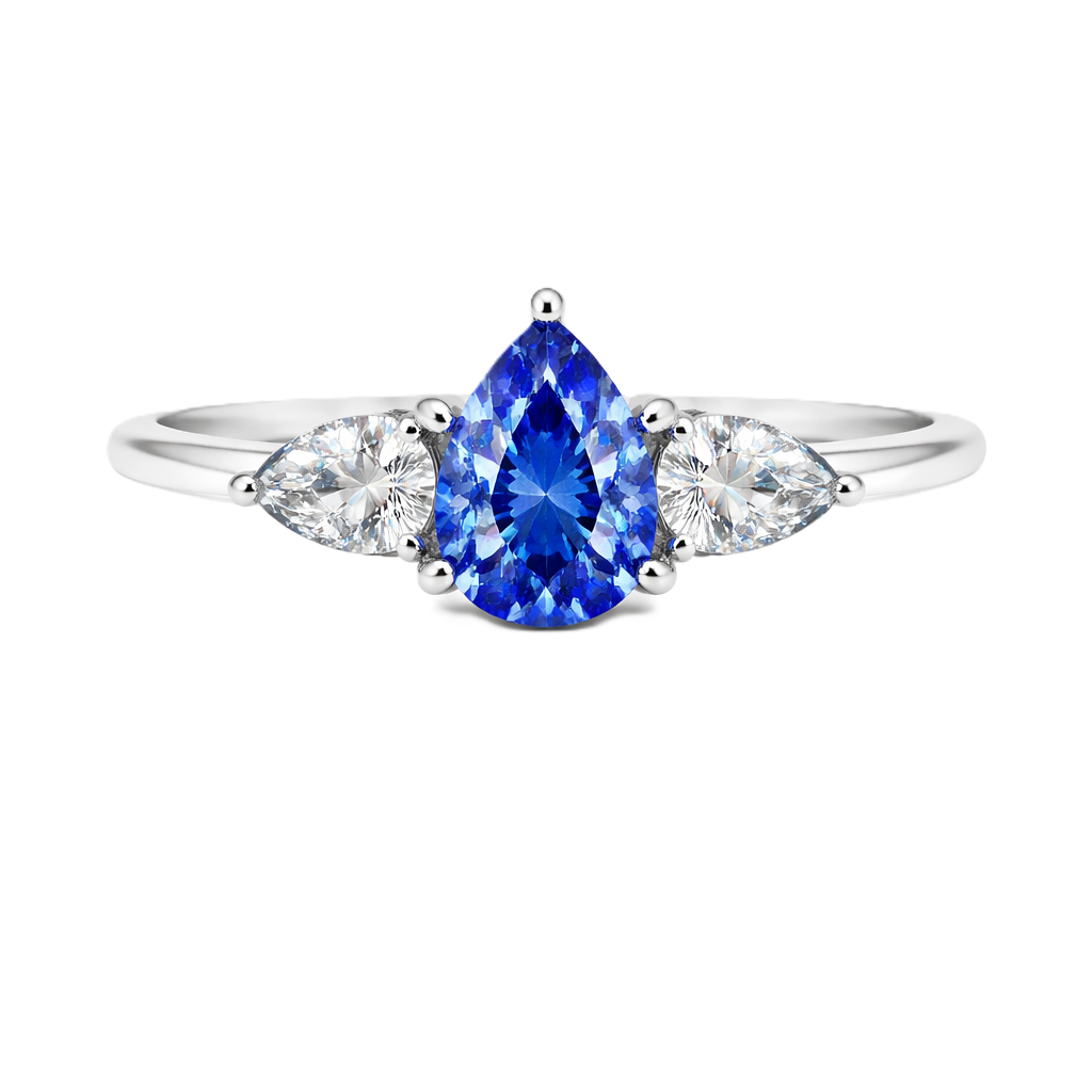 Blue sapphire ring with 7×5 mm pear center and side stones in white gold-plated 925 silver. Elegant and timeless for daily wear. Available now at BSI Jewelry.