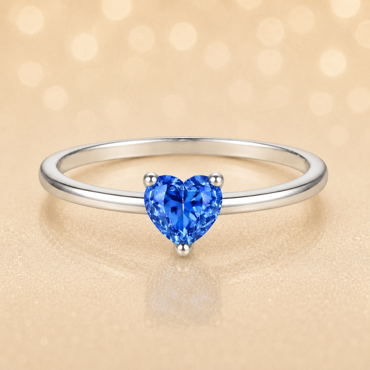 Blue sapphire solitaire ring with a 5 mm heart in white gold-plated 925 silver. Elegant, minimal, and timeless for daily wear. Available now at BSI Jewelry.