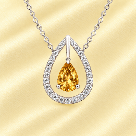 Citrine necklace with a 7×5 mm pear-cut in white gold-plated 925 silver, accented by a moissanite halo. Elegant and refined. Available now at BSI Jewelry.