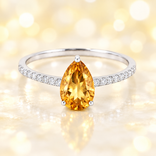 Citrine ring with a 7×5 mm pear-cut stone and moissanite accents in white gold plated 925 silver. Elegant for daily wear. Available now at BSI Jewelry.