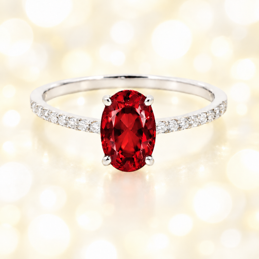 Garnet ring with a 7×5 mm oval-cut stone and moissanite accents in white gold plated 925 silver. Elegant for daily wear. Available now at BSI Jewelry.