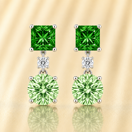 Green sapphire drop earrings with 6 mm princess and round cuts, crafted in white gold-plated 925 silver. Elegant and colorful. Available now at BSI Jewelry.