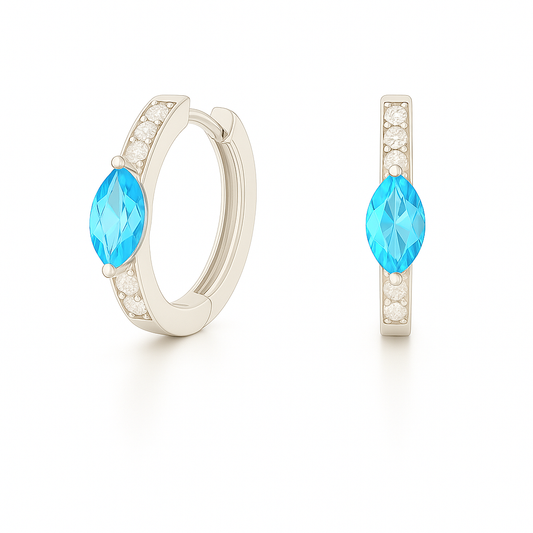 Huggie earrings with Swiss blue topaz marquise and Moissanite accents in white gold-plated 925 silver. Hypoallergenic, safe to wear. Available at BSI Jewelry.