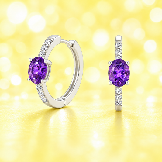 Elegant oval-cut amethyst huggie earrings in white gold-plated 925 silver with sparkling Moissanite accents for vibrant purple brilliance. Now at BSI Jewelry.
