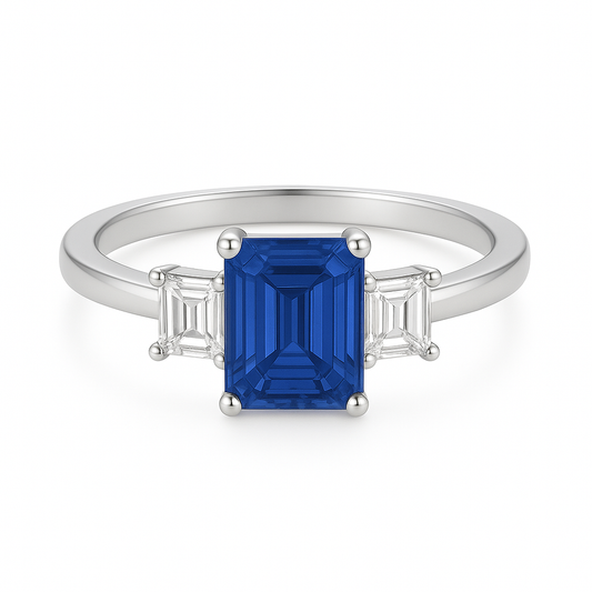7×5 mm emerald-cut blue sapphire ring with baguette Moissanite accents in white-gold-plated 925 silver. Brilliant color and timeless charm. Now at BSI Jewelry.
