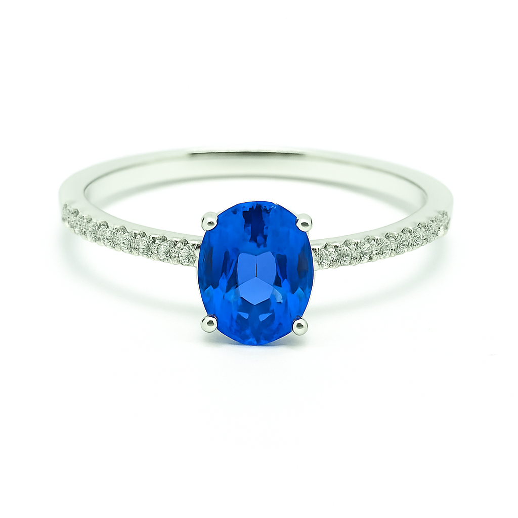 Radiant 7×5 mm blue sapphire oval engagement ring accented with Moissanite, in white gold-plated 925 silver and palladium alloy. Available now at BSI Jewelry.