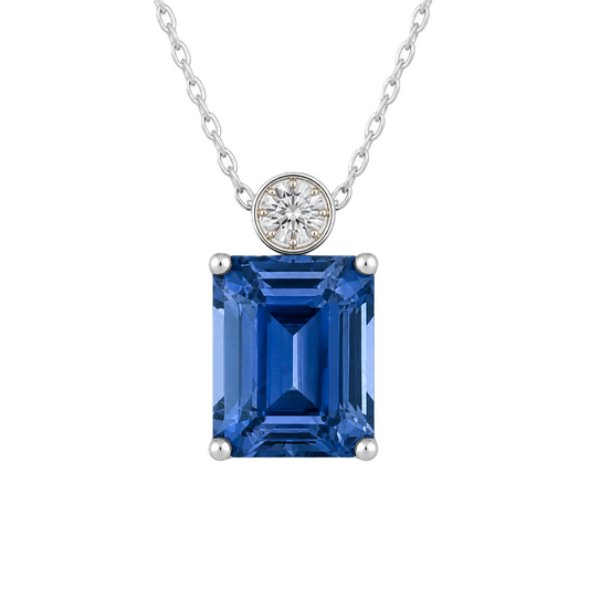Blue sapphire & Moissanite pendant with 7×5 mm emerald-cut stone in white gold-plated 925 silver. Elegant sparkle and hypoallergenic. Available at BSI Jewelry.