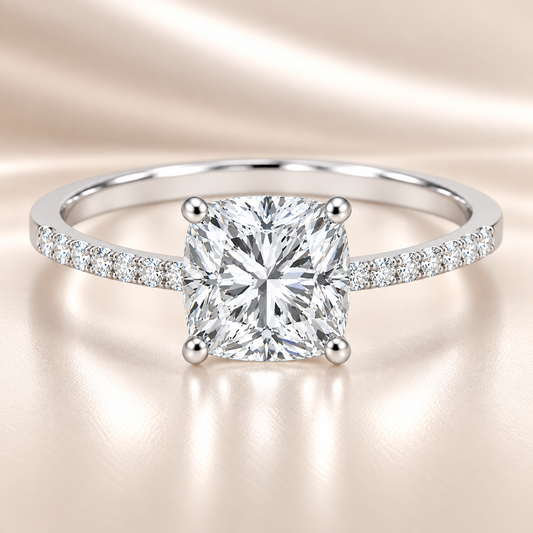Moissanite cushion ring with a 6 mm cushion-cut, accented by moissanite in white gold-plated 925 silver. Elegant and timeless. Available now at BSI Jewelry.