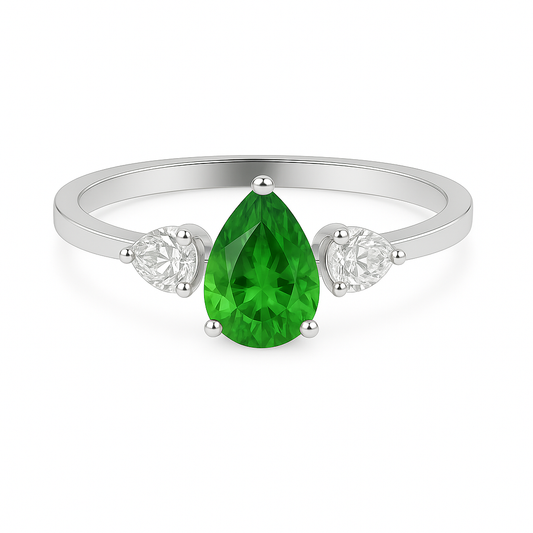 Vibrant pear-cut green sapphire with two pear-cut Moissanite side stones in white-gold-plated 925 silver. Elegant three-stone ring. Available now at BSI Jewelry.