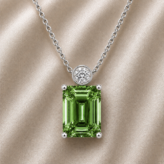 Green sapphire & Moissanite pendant with 7×5 mm emerald-cut stone in white gold-plated 925 silver. Elegant sparkle and hypoallergenic. Available at BSI Jewelry.