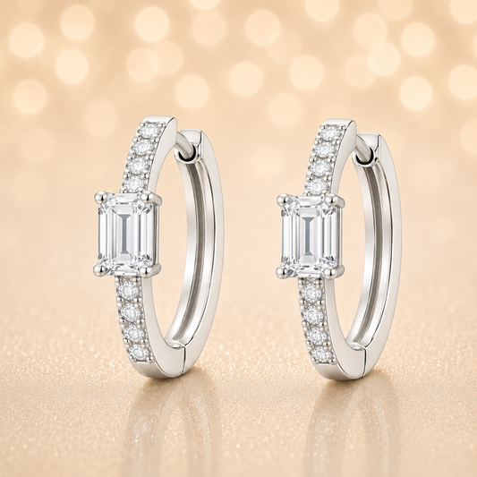 Moissanite huggie earrings, 5×3 mm emerald cut in white gold plated 925 silver. Elegant pavé hoop design with brilliant sparkle. Available now at BSI Jewelry.