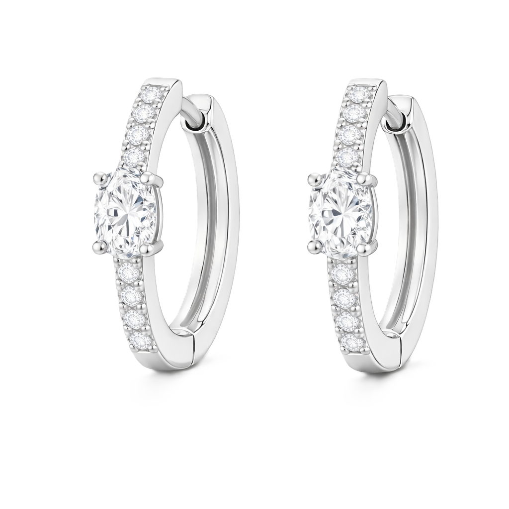 Moissanite huggie earrings, 5×3 mm oval cut in white gold plated 925 silver. Elegant pavé hoop design with brilliant sparkle. Available now at BSI Jewelry.