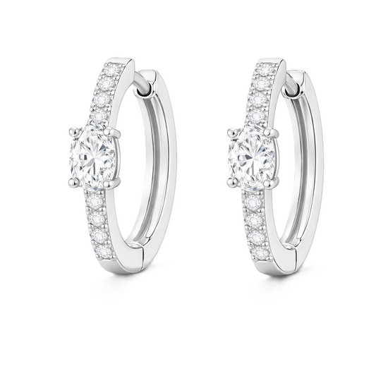 Moissanite huggie earrings, 5×3 mm oval cut in white gold plated 925 silver. Elegant pavé hoop design with brilliant sparkle. Available now at BSI Jewelry.