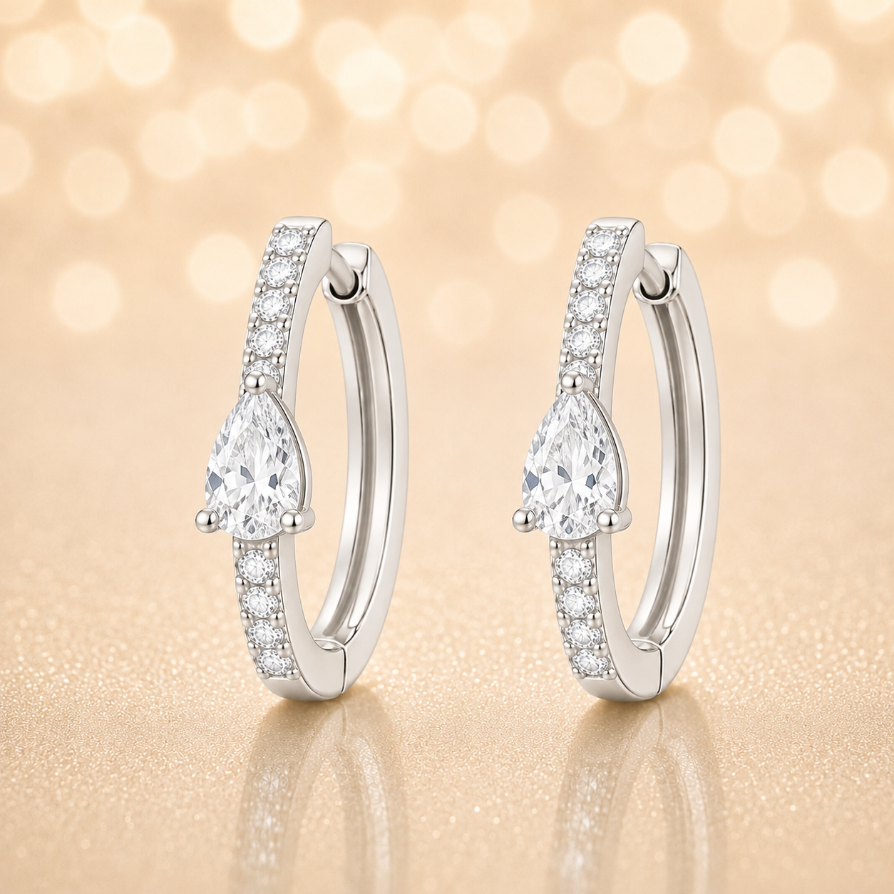 Moissanite huggie earrings, 5×3 mm pear cut in white gold plated 925 silver. Elegant pavé hoop design with brilliant sparkle. Available now at BSI Jewelry.