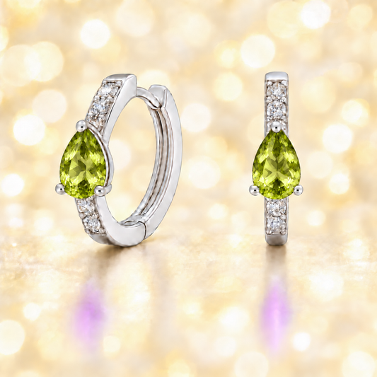 Vivid pear-cut peridot huggie earrings in white gold-plated 925 silver with Moissanite accents for a fresh, elegant sparkle. Available now at BSI Jewelry.