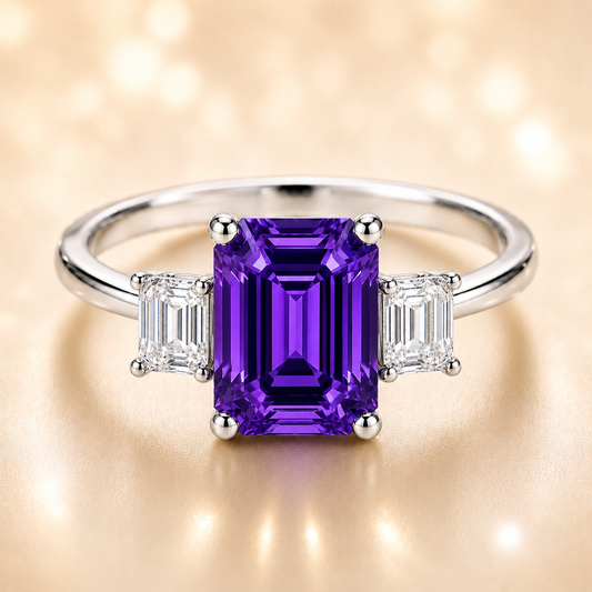 7×5 mm emerald-cut purple sapphire ring with baguette Moissanite accents in white-gold-plated 925 silver. Romantic brilliance. Available now at BSI Jewelry.