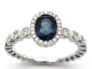 Elegant sapphire halo ring in white gold-plated 925 silver, framed with Moissanite for radiant brilliance. Hypoallergenic silver. Available now at BSI Jewelry.