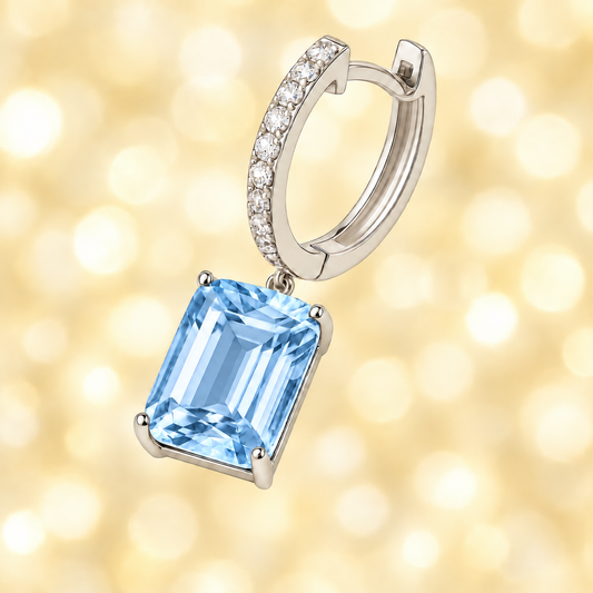 Moissanite & Sky Blue Topaz Huggie Earrings, 8×6 mm emerald cut, crafted in white gold-plated 925 silver. Elegant and hypoallergenic. Available at BSI Jewelry.