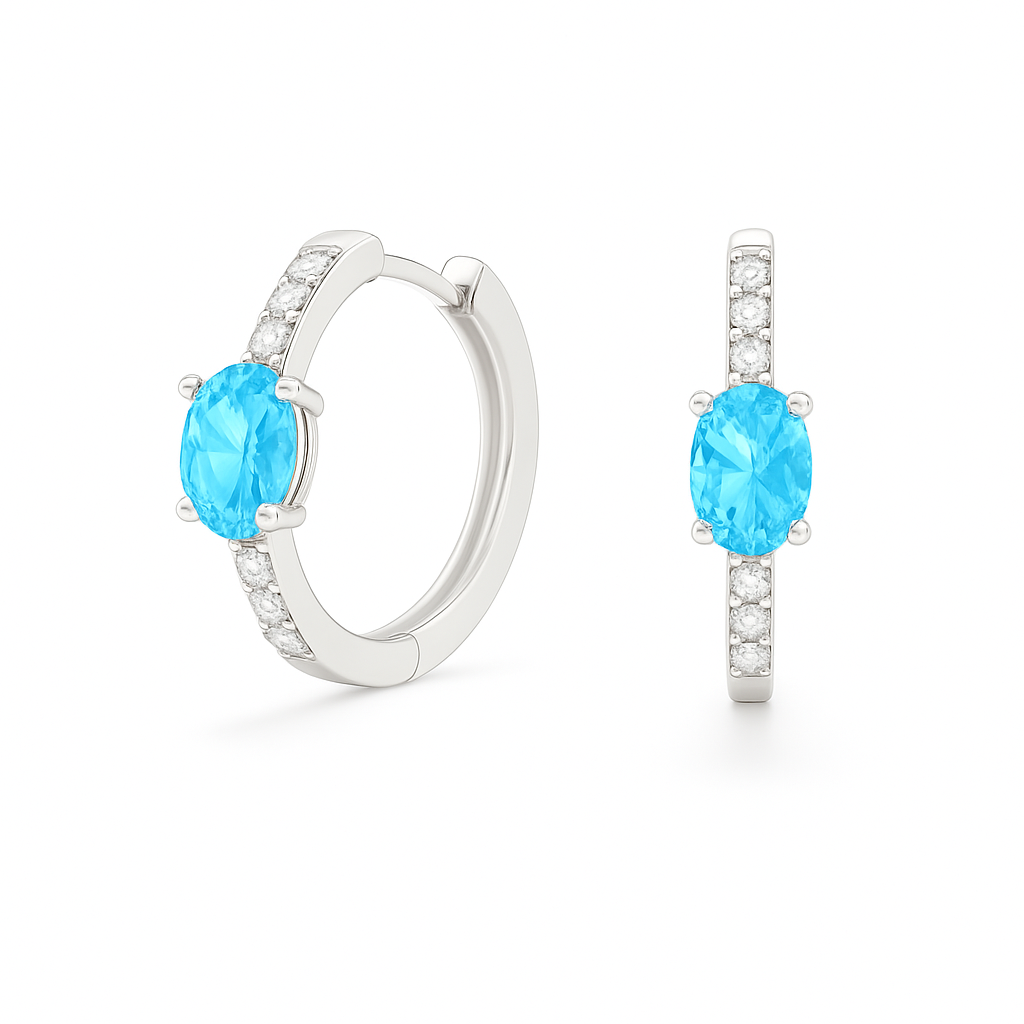 Elegant oval-cut Swiss blue topaz huggie earrings in white gold-plated 925 silver with sparkling Moissanite accents for a fresh charm. Available at BSI Jewelry.
