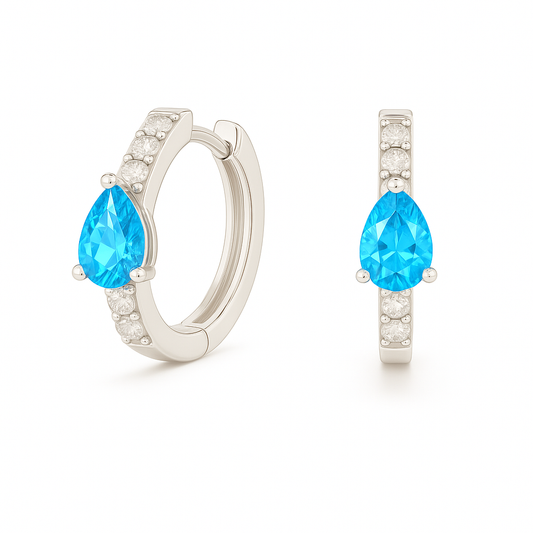 Elegant pear-cut Swiss blue topaz huggie in white gold-plated 925 silver with Moissanite accents for fresh, versatile sparkle. Available now at BSI Jewelry.