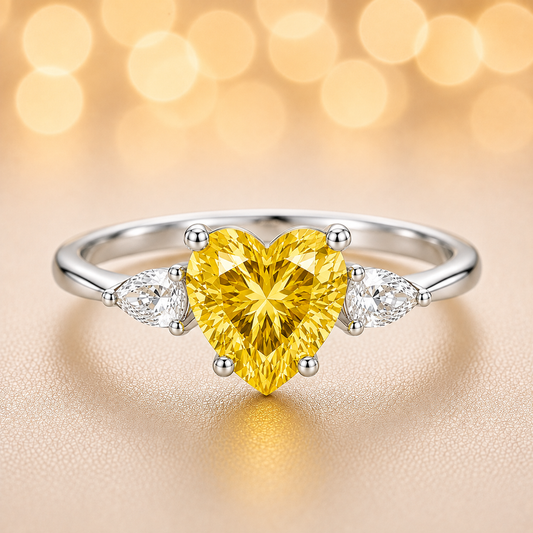 6 mm heart-cut yellow sapphire ring with pear-shaped Moissanite accents, set in white-gold-plated 925 silver. Romantic and charming. Available at BSI Jewelry.