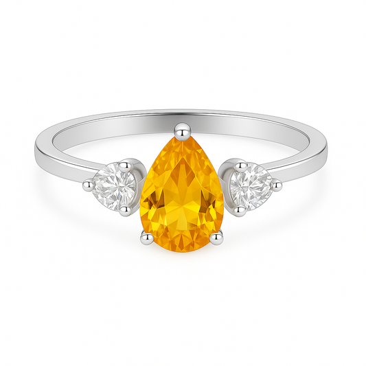 Pear-cut yellow sapphire ring flanked by pear-cut Moissanite side stones in white-gold-plated 925 silver. Vibrant, radiant, and elegant. Available at BSI Jewelry.