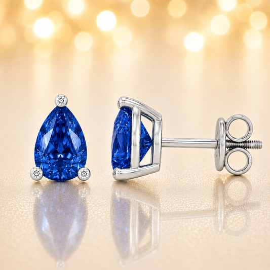 Pear blue sapphire stud earrings with 6×4 mm stones and moissanite prongs in white gold plated 925 silver. Available now at BSI Jewelry.