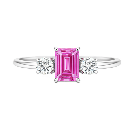 Pink sapphire ring, 6×4 mm emerald cut with 3 mm moissanite sides, set in white gold-plated 925 silver. Elegant and hypoallergenic. Available now at BSI Jewelry.