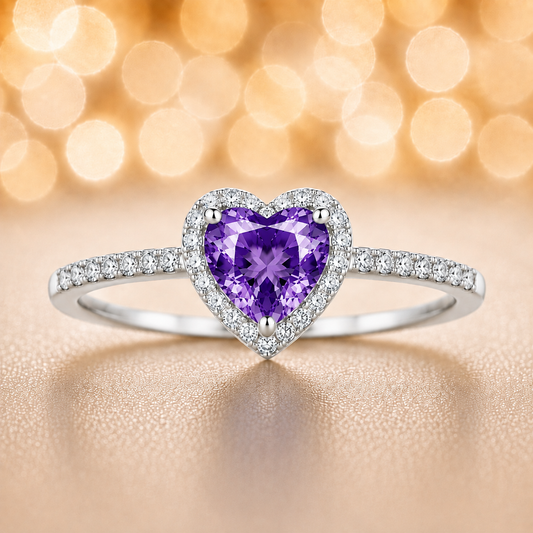 Purple sapphire ring with a 6 mm heart cut, accented by moissanite in white gold-plated 925 silver. Elegant and timeless. Available now at BSI Jewelry.