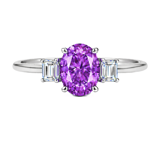 Purple sapphire ring with 7×5 mm oval center and 5×3 mm moissanite sides in white gold-plated 925 silver. Elegant and refined. Available now at BSI Jewelry.