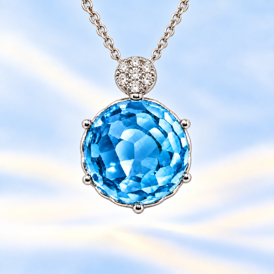 Round sky blue topaz pendant with an 8 mm cabochon gemstone in white gold-plated 925 silver. Elegant and hypoallergenic. Available now at BSI Jewelry.