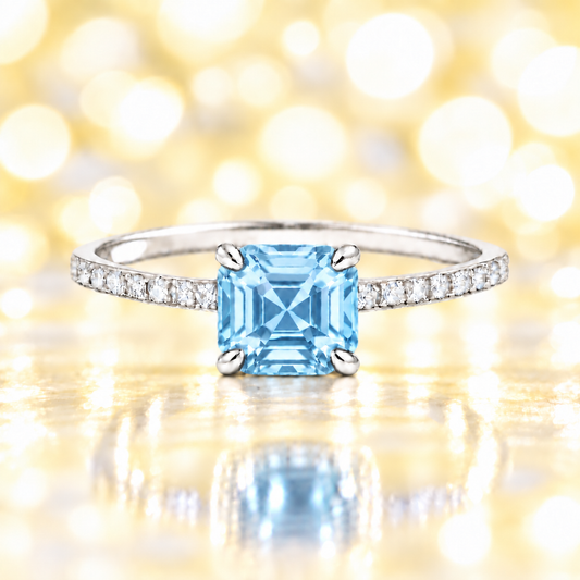 Sky blue topaz ring with a 6 mm Asscher-cut in white gold-plated 925 silver, accented with moissanite and fresh blue brilliance. Available now at BSI Jewelry.