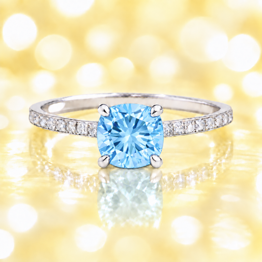 Sky blue topaz ring with a 6 mm cushion in white gold-plated 925 silver, accented with moissanite. Fresh and elegant for daily wear. Available now at BSI Jewelry.