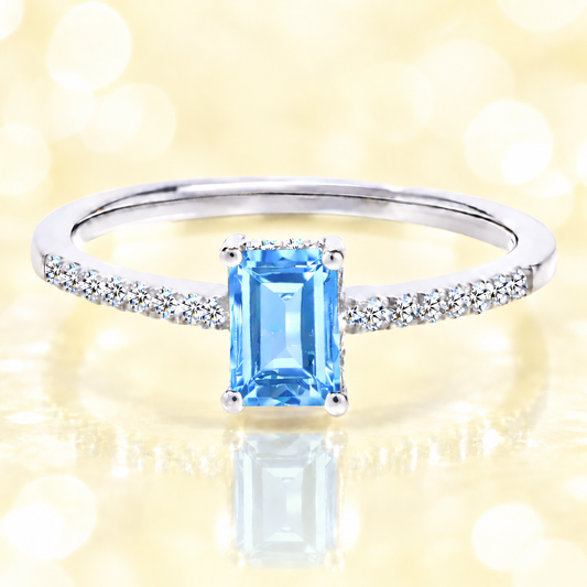 Sky blue topaz ring with a 7×5 mm emerald cut in white gold-plated 925 silver, with moissanite. Elegant and refined for daily wear. Available now at BSI Jewelry.