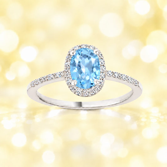 Sky blue topaz ring with a 7×5 mm oval-cut stone, accented by moissanite in white gold-plated 925 silver. Fresh and elegant. Available now at BSI Jewelry.