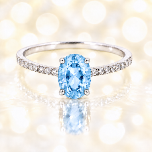 Sky blue topaz ring with a 7×5 mm oval-cut stone and moissanite accents in white gold plated 925 silver. Elegant for daily wear. Available now at BSI Jewelry.