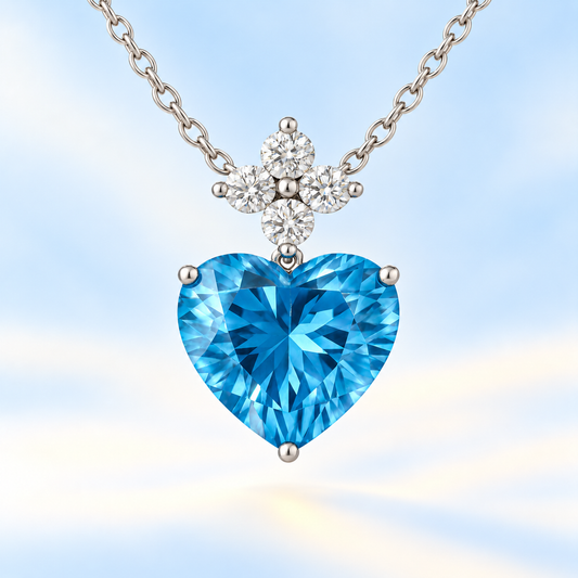 Elegant 7mm heart-cut Swiss Blue Topaz pendant with Moissanite accents in white-gold-plated 925 silver. Timeless and ocean-blue charm. Available at BSI Jewelry.