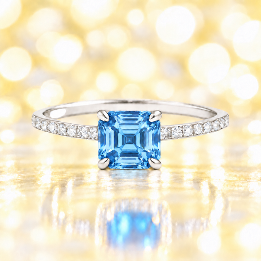 Swiss blue topaz ring with a 6 mm Asscher-cut in white gold-plated 925 silver, accented with moissanite and vivid blue brilliance. Available now at BSI Jewelry.