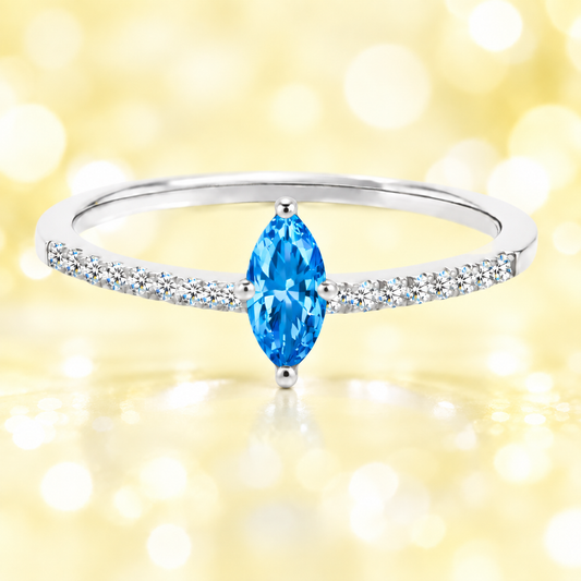 Swiss blue topaz ring with an 8×4 mm marquise-cut stone, accented by moissanite in white gold-plated 925 silver. Fresh and vibrant. Available now at BSI Jewelry.