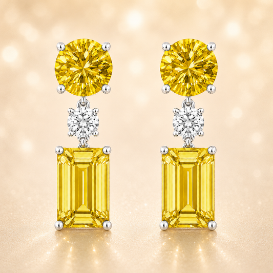 Yellow sapphire drop earrings with 5mm round and 6×4mm emerald cut, crafted in white gold-plated 925 silver with palladium-added alloy. Available at BSI Jewelry