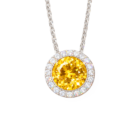 Yellow sapphire pendant with 6 mm round stone in white gold-plated 925 silver, accented with moissanite and adjustable cable chain. Available now at BSI Jewelry.