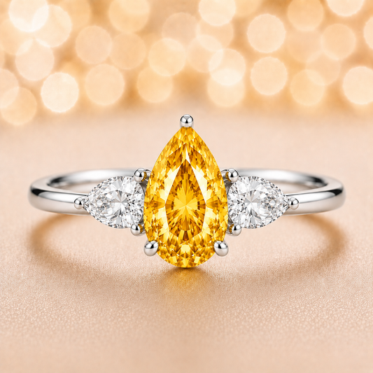 Yellow sapphire ring with 7×5 mm pear center and side stones in white gold-plated 925 silver. Bright and elegant for daily wear. Available now at BSI Jewelry.